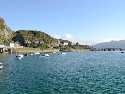 a group of boats in the water near a beach at Barreg in Barmouth