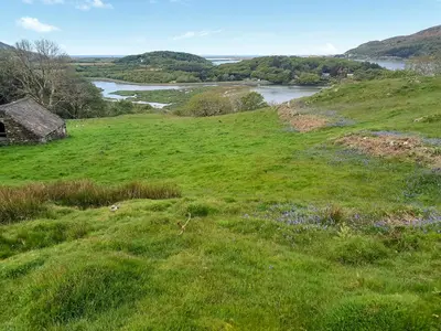 a green field with a river in the distance at Erw Goed Hen Stabl in Arthog