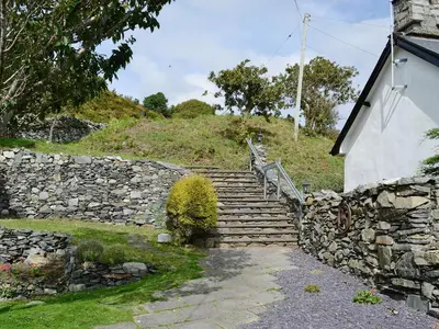 a set of stone steps with a stone wall and a stair case at Cae-Fadog Fach in Barmouth