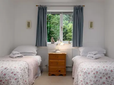 two twin beds in a room with a window at Treetops in Fairbourne