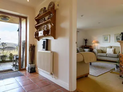 a living room with a couch and a table at Treetops in Fairbourne