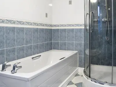 a white bath tub in a bathroom with a shower at Ysgubor in Harlech