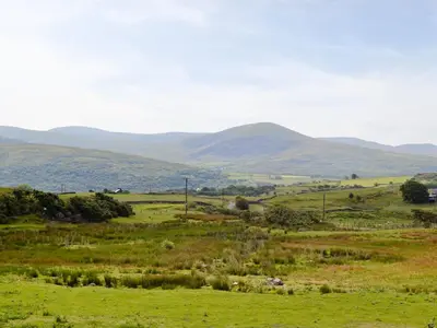 a green field with mountains in the distance at Beudy Hen in Harlech