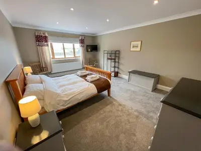 a bedroom with a bed and a desk and a window at Bod Eithin in Harlech