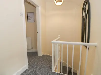 a hallway with a spiral staircase and a stairwayngthngthngthngthngthngth at 5 Tai Isa in Barmouth