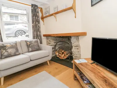 a living room with a couch and a fireplace at 5 Tai Isa in Barmouth