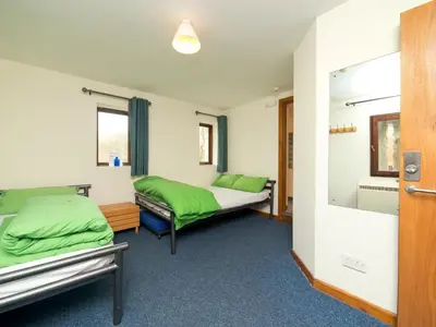a hospital room with two beds and a mirror at YHA Brecon Beacons in Brecon