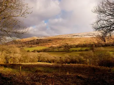 a hill in the distance with a field and trees at YHA Brecon Beacons in Brecon