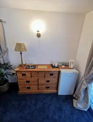 a room with a dresser with a lamp on it at Bryn Mynach Guest House in Barmouth