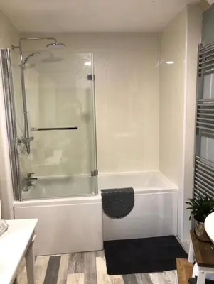 a white bathroom with a shower and a tub at Bryn Mynach Guest House in Barmouth
