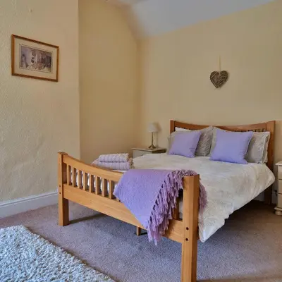 a bedroom with a large bed with purple pillows at Country Cottage with Far Reaching Views in Presteigne
