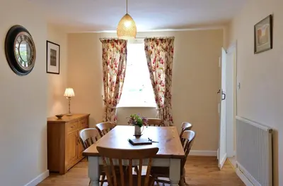 a dining room with a table and chairs and a window at Country Cottage with Far Reaching Views in Presteigne