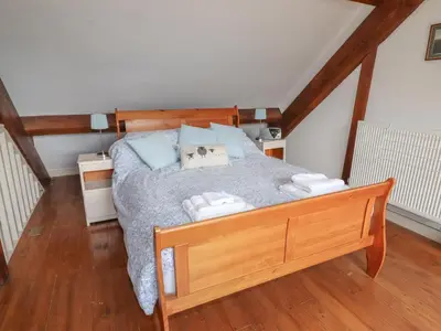 a bedroom with a wooden bed with towels on it at Chapel House in Llangollen