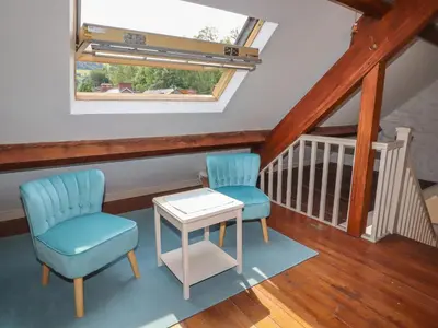 a room with two chairs and a table and a window at Chapel House in Llangollen