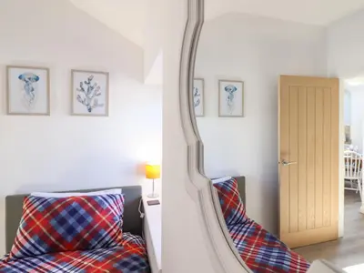 a bedroom with a mirror and a bed and a chair at Tan Llech in Harlech
