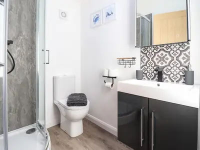 a bathroom with a toilet and a sink and a shower at Tan Llech in Harlech