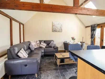 a living room with a couch and a table at Ysgubor Fachwen in Newtown