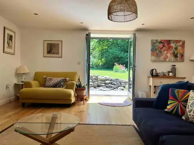 a living room with a couch and a glass table at Crymlyn barn in Llanwrda