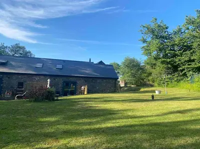 a brick house with a large yard in front of it at Crymlyn barn in Llanwrda