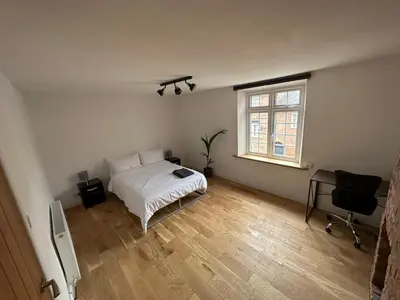 a bedroom with a bed and a desk and a window at Newtown Townhouse in Newtown