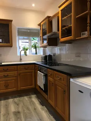 a kitchen with wooden cabinets and a black counter top at Newtown Townhouse in Newtown