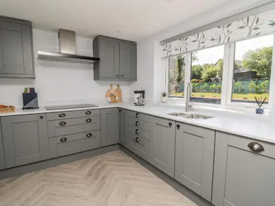 a kitchen with gray cabinets and a window at Rhiwmynach in Aberystwyth