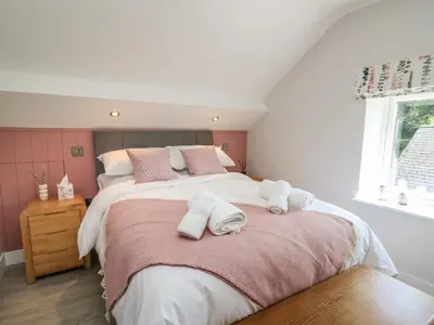 a bedroom with a large bed with towels on it at Rhiwmynach in Aberystwyth