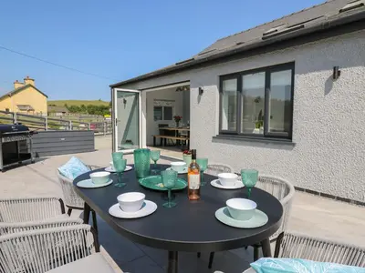 a black table with plates and drinks on a patio at Rhiwmynach in Aberystwyth