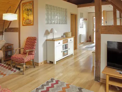 a living room with a television and a chair at The Loft At Callow Fold in Eaton