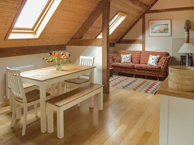 a living room with a table and a couch at The Loft At Callow Fold in Eaton