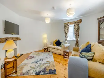 a living room with a couch and a tv at Y Beudy in Capel Bangor