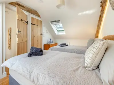 a bedroom with two beds and a skylight at Y Beudy in Capel Bangor