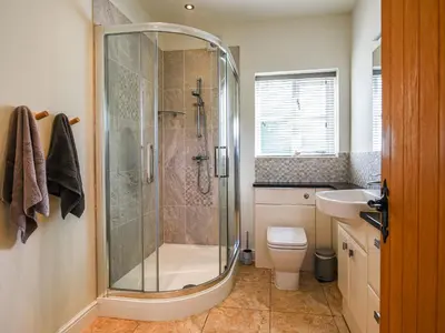 a bathroom with a shower and a toilet and a sink at Orchard View in Minsterley