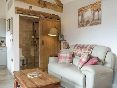 a living room with a couch and a table at Cosy and quiet one bed barn conversion. in Church Stretton