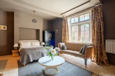 a bedroom with a bed and a couch and a table at Llanerchydol Hall Suites in Welshpool