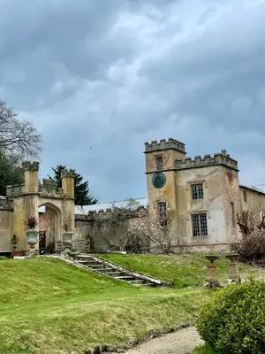 an old castle with a grassy yard in front of it at Llanerchydol Hall Suites in Welshpool