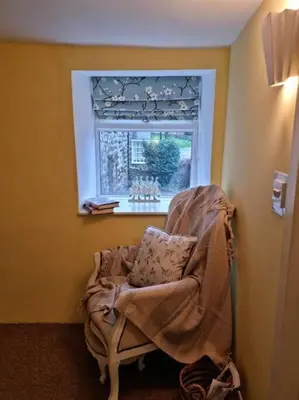 a chair in a room with a window at Glasfor Cottage in Llwyngwril