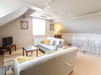 a living room with a couch and a tv at Rock House Apartment in Newtown