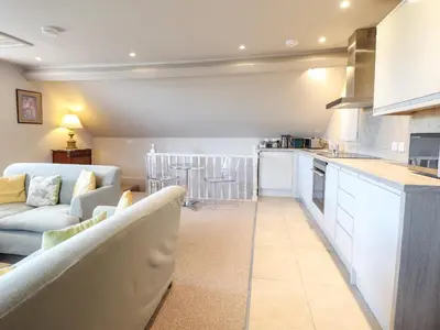 a living room with a couch and a kitchen at Rock House Apartment in Newtown