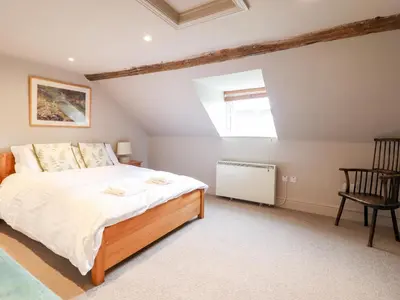 a bedroom with a bed and a chair and a window at Rock House Apartment in Newtown