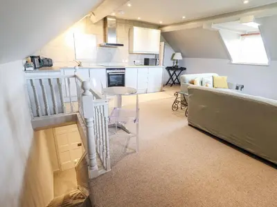 a kitchen and living room with a couch and a table at Rock House Apartment in Newtown