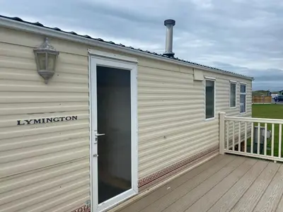 a large building with a door on a deck at 98Lemmington by the beach Ynyslas, Borth in Borth