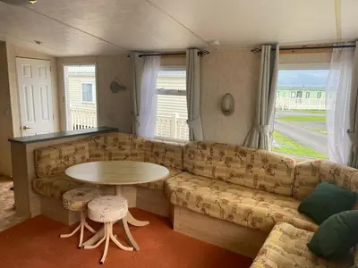 a living room with a couch and a table at 98Lemmington by the beach Ynyslas, Borth in Borth