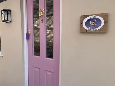 a pink door with a dog sign on it at Cottage with outstanding views in Velindre