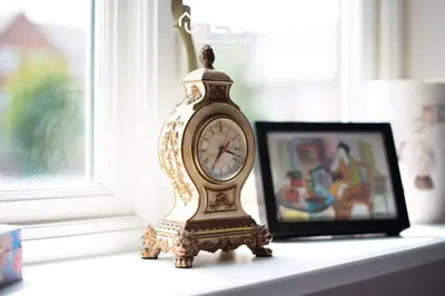 a clock sitting on a table next to a picture at 4 Bedroom Townhouse 10mins walk from Shrewsbury Town Centre with Parking in Shrewsbury