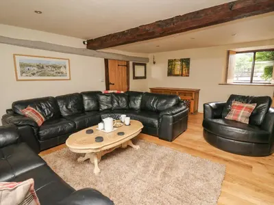 a living room with black leather couches and a table at Penarth in Llandrindod Wells