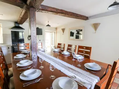 a dining room with a long table with plates and wine glasses at Penarth in Llandrindod Wells