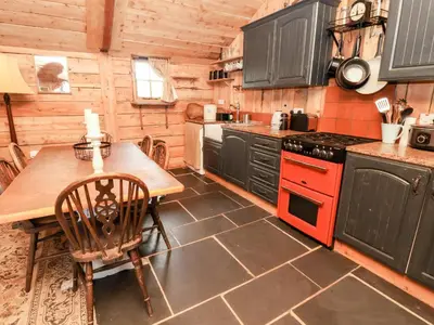 a kitchen with a table and a stove top oven at Y Caban in Llangollen
