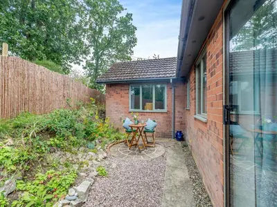 a small patio with a table next to a building at High Bank in Pontesbury