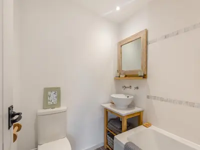 a white bathroom with a sink and a mirror at High Bank in Pontesbury